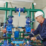 A professional performs boiler and pump maintenance in a commercial building.