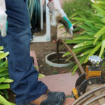 A licensed plumber is cleaning out a clog from a sewer line.